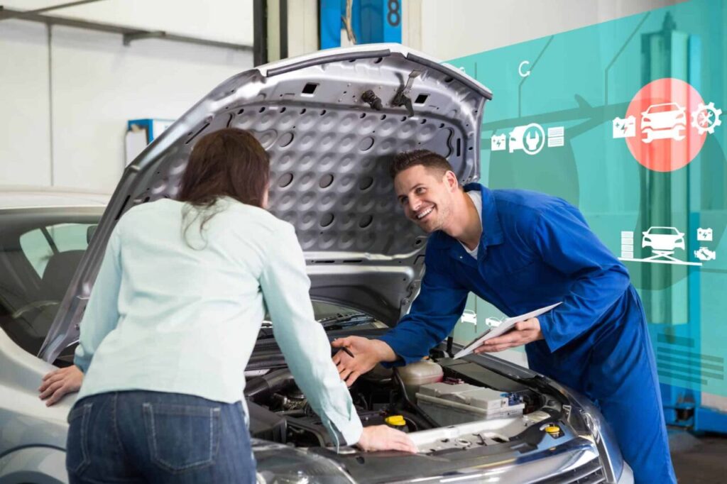 Imagem de mecânico vistoriando o carro de uma mulher