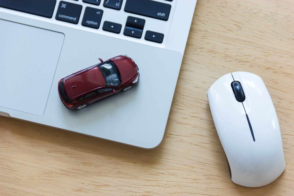 mouse ao lado de um notebook com um carro de brinquedo em cima