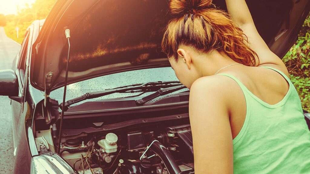 O motor de arranque parou? Como evitar que isso se repita 4 Mulher olhando para o motor de um carro com defeito - motor de arranque