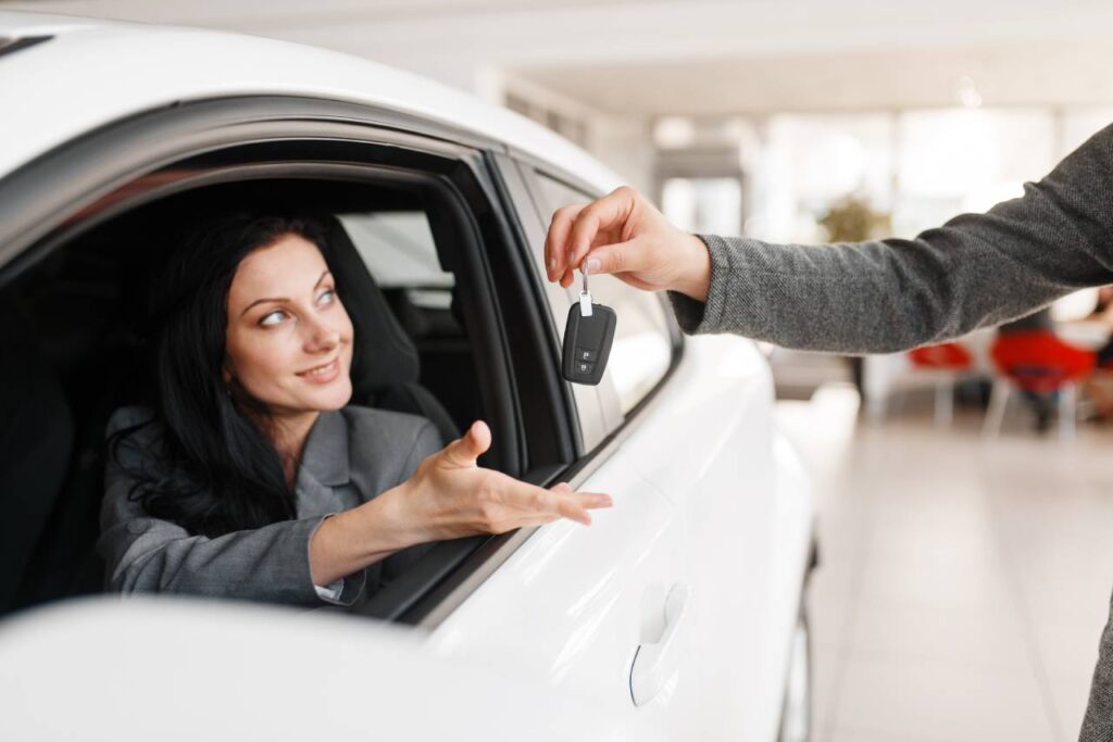 Os melhores carros até R$ 30 mil usados 7 mulher feliz dentro do carro recendo a chave - carros até 30 mil