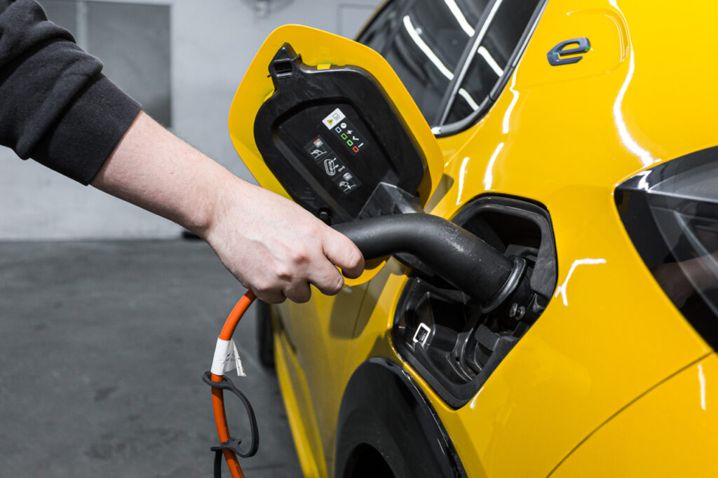 É confiável a autonomia de bateria dos carros elétricos? 4 Peugeot 208 elétrico amarelo - tomada de recarga do Peugeot aluguel carregador carros elétricos